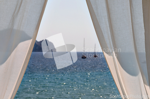 Image of white curtains boats by the sea