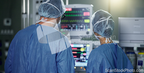 Image of Teamwork, screen monitor or surgeon in surgery procedure or healthcare operation in hospital. Night, back view or doctors in face mask working or helping in dark operating room in medical clinic