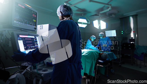 Image of Back, medicine and monitor with a doctor in theater for surgery or a healthcare procedure at the hospital. Medical, technology and equipment with a professional surgeon in a clinic for an operation