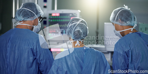 Image of Teamwork, back or surgeon in surgery emergency procedure or healthcare operation in hospital. Night, monitor or doctors in face mask or collaboration helping in dark theatre room in medical clinic