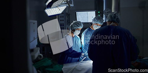 Image of Surgery, dark room and doctors with healthcare, teamwork and support with wellness, safety and emergency. People, medical professionals or group with cooperation, theatre and medicine in hospital