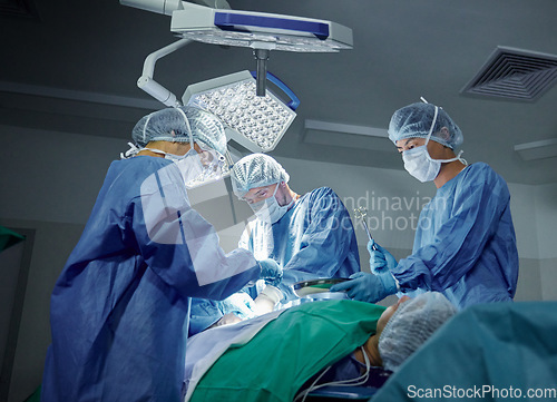 Image of Collaboration, healthcare and doctors working on a surgery for medical treatment in a theatre room. Teamwork, career and professional surgeons doing an operation on a patient in a hospital or clinic.