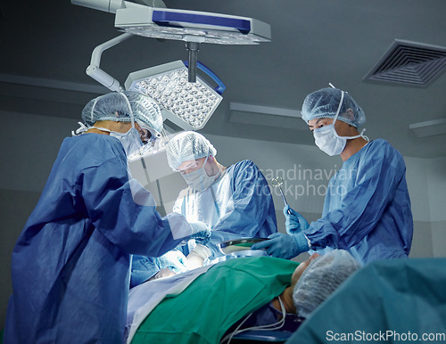 Image of Teamwork, healthcare and doctors working on a surgery for medical treatment in a theatre room. Collaboration, career and professional surgeons doing an operation on a patient in a hospital or clinic.