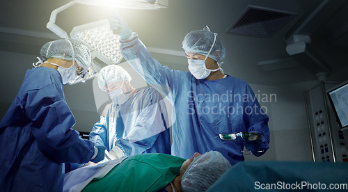 Image of Teamwork, healthcare and surgeons working on a surgery for medical treatment in a theatre room. Collaboration, career and professional doctors doing an operation on a patient in a hospital or clinic.