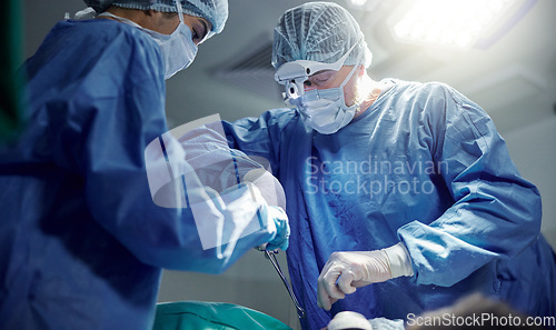 Image of Healthcare, teamwork and doctors in a hospital for surgery together, working in theater to save a life. Medical, emergency and a surgeon team in the operating room of a clinic for an operation