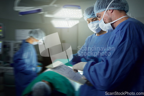 Image of Healthcare, surgeon and a team in a hospital for surgery together, working in theater to save a life. Medical teamwork, emergency and doctors in the operating room of a clinic for an operation