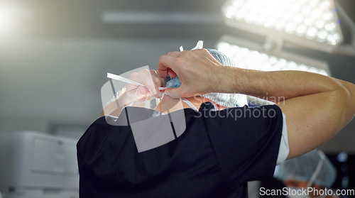 Image of Surgeon, hands and man tie mask in hospital, operating room and medical theater with safety compliance. Doctor, back and protection in surgery from bacteria, germs or virus in health care clinic