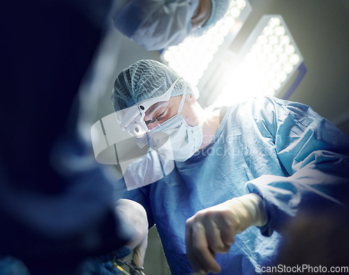 Image of Healthcare, teamwork and doctors in theater for surgery together, working in a clinic to save a life. Medical, emergency and a surgeon team in the operating room of a hospital for an operation