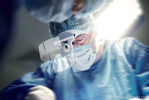 Image of Headlight, healthcare and doctors in a hospital for surgery together, working in theater to save a life. Medical, teamwork and a surgeon in the operating room of a clinic for an operation closeup