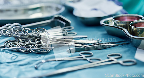 Image of Background, surgery and metal tools in operating room for hospital assessment, healthcare service or emergency in medical theatre. Closeup, surgical equipment and scissors with forceps for operation