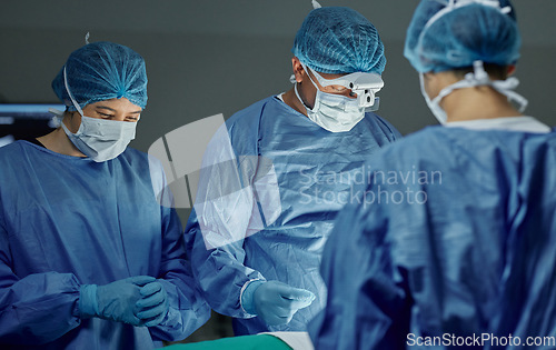 Image of Teamwork, healthcare and doctors working on an operation for medical treatment in a theatre room. Collaboration, career and professional surgeons doing a surgery on a patient in a hospital or clinic.