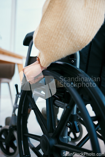 Image of Hand, wheelchair and patient with a disability closeup in a home for recovery or mobility from the back. Healthcare, medical and injury with a person in a hospital or clinic for rehabilitation