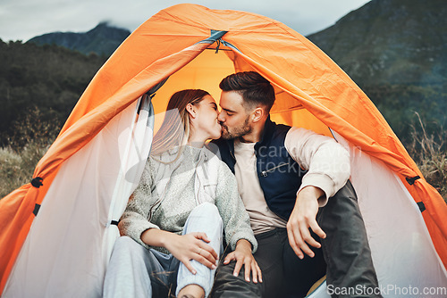 Image of Couple, kiss and tent in camping on mountain for love, care or affection in nature together. Woman kissing man on camp site for romantic getaway, holiday vacation or weekend in outdoor bonding