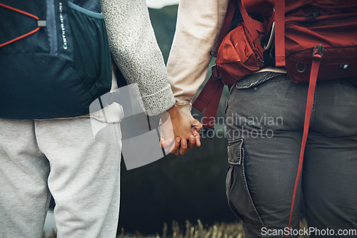 Image of Couple, holding hands and backpack in nature for hiking, adventure or outdoor journey together. Rear view or closeup of hiker, people or backpacking in teamwork for trekking, motivation or support