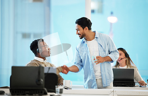 Image of Call centre, man and handshake for teamwork in office for telecom, customer care and services. Diversity, manager and thank you for employee with headset, work and feedback on crm, web or sales