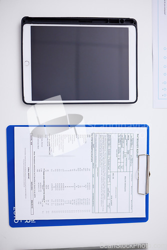 Image of Above, table, tablet and healthcare report at a hospital with results for a chart and medical paperwork. Desk, clinic work and technology for communication with a document for insurance in office