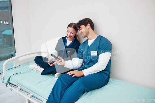 Image of Doctor, students and break on phone on a hospital, healthcare and clinic bed with social media. Media, mobile and happy young people together with rest from medical and nursing internship on a app