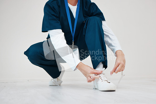 Image of Healthcare, shoes and tie with hands of a nurse in studio while getting ready for medical service closeup. Medical, lace and dressing with a medicine professional in uniform at a clinic for nursing