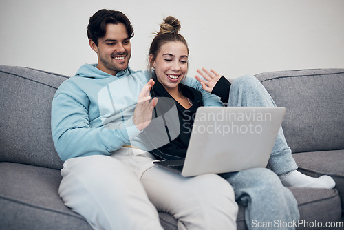 Image of Couple, video call and wave on laptop in living room with communication for family. Young man, woman and together in happiness, embrace or love in relationship on sofa with technology, web or app