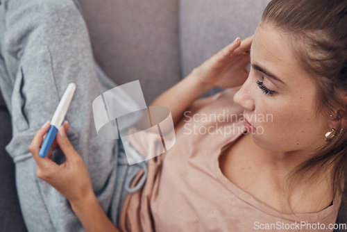 Image of Pregnancy test, sad and woman on sofa in home, reading bad news or negative results. Stick, serious and frustrated pregnant mother depressed in living room for fail, stress or anxiety for infertility