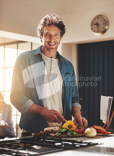 Image of Smile, portrait and man chop vegetables in the kitchen for diet, healthy or nutrition dinner. Happy, cooking and mature male person from Canada cutting ingredients for a supper or lunch meal at home.