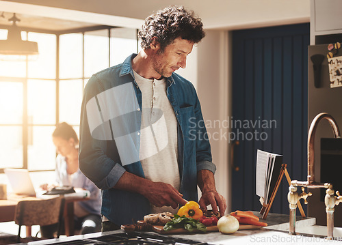 Image of Cooking, food and man cutting vegetables in the kitchen for diet, healthy or nutrition dinner. Recipe, book and mature male person from Canada chop ingredients for a supper or lunch meal at home.