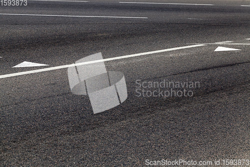 Image of close-up of an asphalt road with white road markings