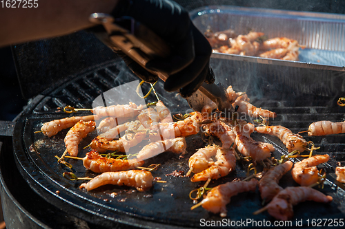 Image of A professional cook prepares shrimps