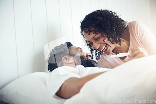 Image of Couple, happy and laughter with pregnancy test, positive and bed with smile, results and excited. Man, woman and baby with stick, love and maternity for future family, surprise and pregnant together