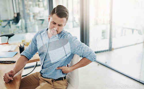 Image of Man, stretching and back pain from chair in office with stress, anxiety or frustrated with injury to muscle. Tired, employee and strain on spine in workplace with fatigue or problem in health