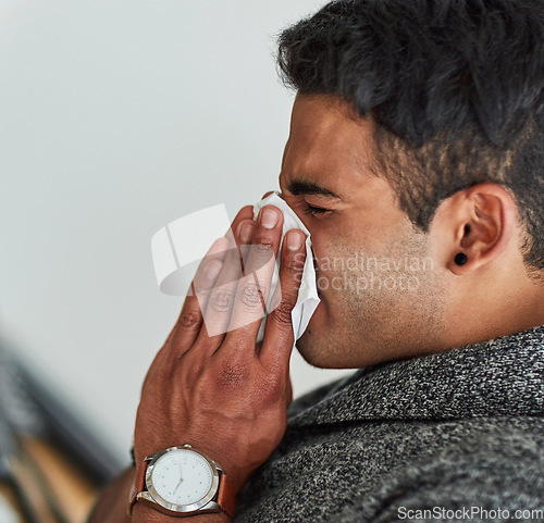 Image of Profile, hand and blowing nose with a man using a tissue closeup in his home for relief from allergy symptoms. Face, sick with a cold or flu and a young person sneezing due to a virus or hay fever