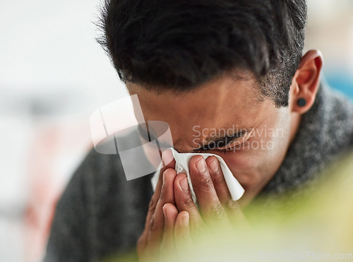 Image of Sick, hands and blowing nose with a man using a tissue closeup in his home for relief from allergy symptoms. Face, cold or flu and a young person ill with a virus due to bacteria, pollen or hay fever