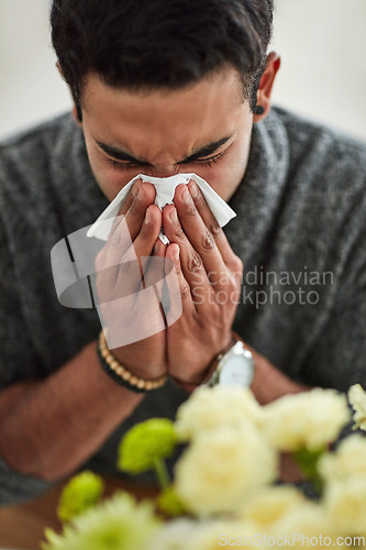 Image of Spring, blowing nose with a man using a tissue closeup in his home for relief from allergy symptoms. Face, cold or flu and a young person sick with a virus due to pollen or hay fever at home