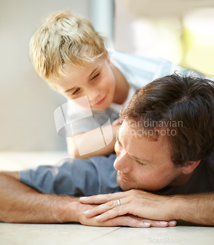 Image of Smile, relax and dad with son on floor, cute bonding together with care and love in home. Fun, father and child lying on ground in house with happy relationship, trust and support with man and boy.