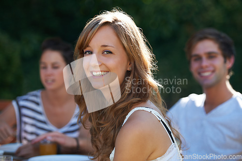 Image of Happy, woman and portrait in backyard with friends at a table with young people and smile. Lunch, home garden and group ready for eating on a summer break together and relax outdoor of a house