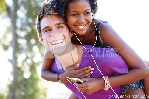 Image of Fitness, smile and happy couple with piggyback hug in a park for training, bond or fun. Interracial, love and face of active man with back ride for woman with music, earphones or audio mp3 player