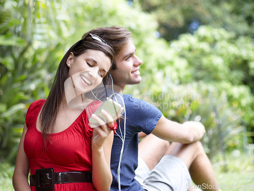 Image of Happy, love and couple relax in a forest with music, conversation and bonding outdoor. Smile, romance and people in a park for date in nature while chilling on and having fun with weekend freedom