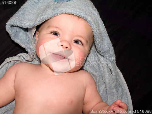 Image of Happy young baby boy in blue towel