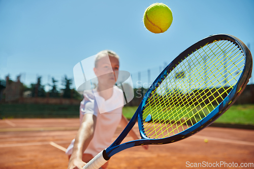 Image of Close up photo of a young girl showing professional tennis skills in a competitive match on a sunny day, surrounded by the modern aesthetics of a tennis court.