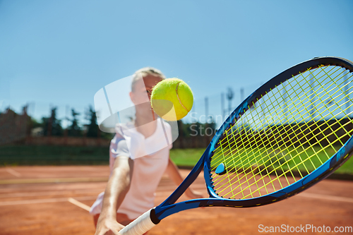 Image of Close up photo of a young girl showing professional tennis skills in a competitive match on a sunny day, surrounded by the modern aesthetics of a tennis court.