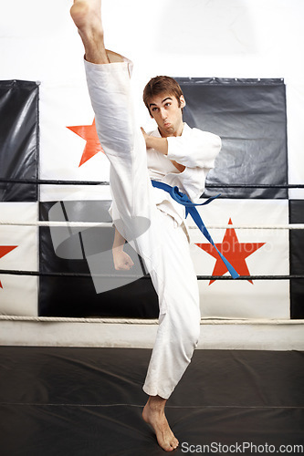 Image of Man, karate and high kick for martial arts in ring, self defense or jiujitsu training for fighting match. Male person, athlete or fighter in MMA boxing, muay thai or fitness practice at dojo or gym