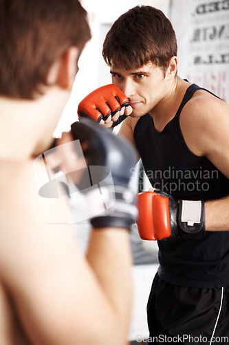 Image of Man, fighting and boxing in martial arts training with sparring partner for self defense techniques at dojo. Male person, athlete or boxer ready for fight, karate or MMA in jujitsu or match in ring