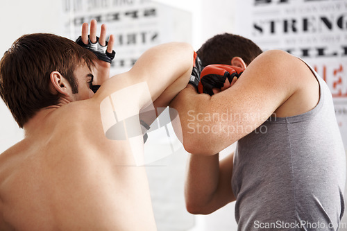 Image of Man, fighting and martial arts with elbow block or sparring partner for self defense techniques at dojo. Male person or fighter in kick boxing, karate or MMA for jujitsu, protection or guard at gym