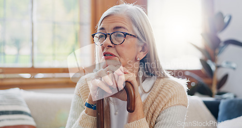Image of Home, thinking and senior woman with anxiety, sad and retirement with depression, mental health or dementia. Mature person, old lady or pensioner with walking stick, alzheimer and relax in a lounge