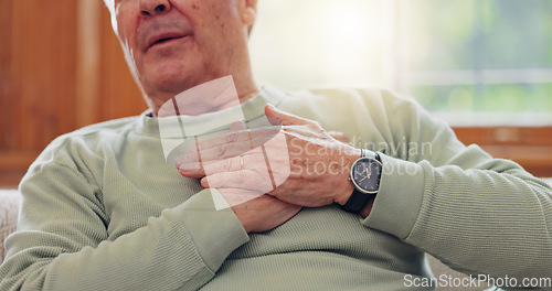 Image of Hands, heart attack or condition with a senior man in pain closeup in the living room of his retirement home. Healthcare, chest or cardiac arrest with an elderly person breathing for lung oxygen