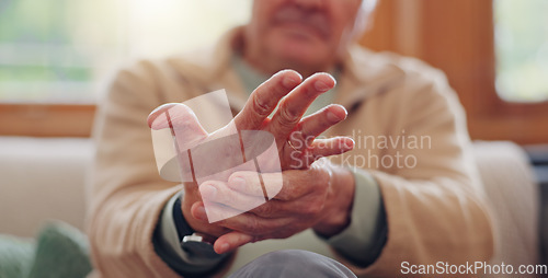 Image of Closeup, hands and senior man with wrist pain, injury and inflammation with bruise, home and broken. Zoom, pensioner and elderly guy on a couch, fingers with ache and arthritis with sprain and strain