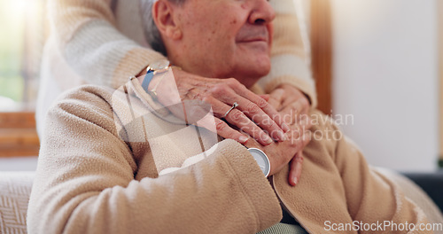Image of Hands, empathy and a senior couple closeup in their home for love, support or trust during retirement. Hope, healing and sympathy with elderly people on a sofa in the living room of their home