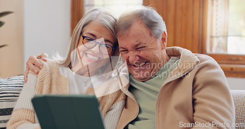 Image of Tablet, social media and a senior couple laughing in the living room of their home together during retirement. Technology, love and relax with funny elderly people looking at a meme on the sofa