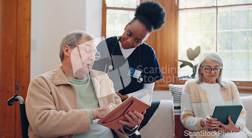 Image of Senior man, reading and nurse talking in home with book, discussion or support from nursing staff. Retirement, elderly care or person relax in conversation with caregiver in living room with notebook