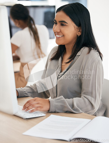 Image of Computer, report and typing with an indian woman in business working on a desktop in her office at work. Internet, email and desktop with a young female employee at work as a professional secretary